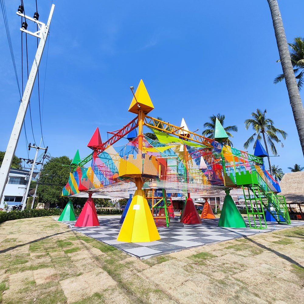The colourful main structure of KO FUN adventure park among palm trees in Rawai, Phuket